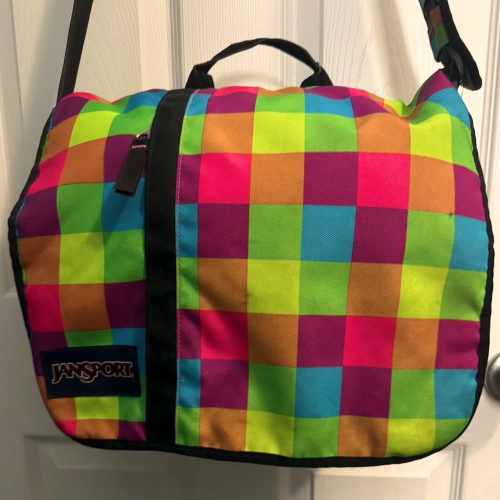 Multicolor Jan-sport brand book bag with inside and front side pockets.